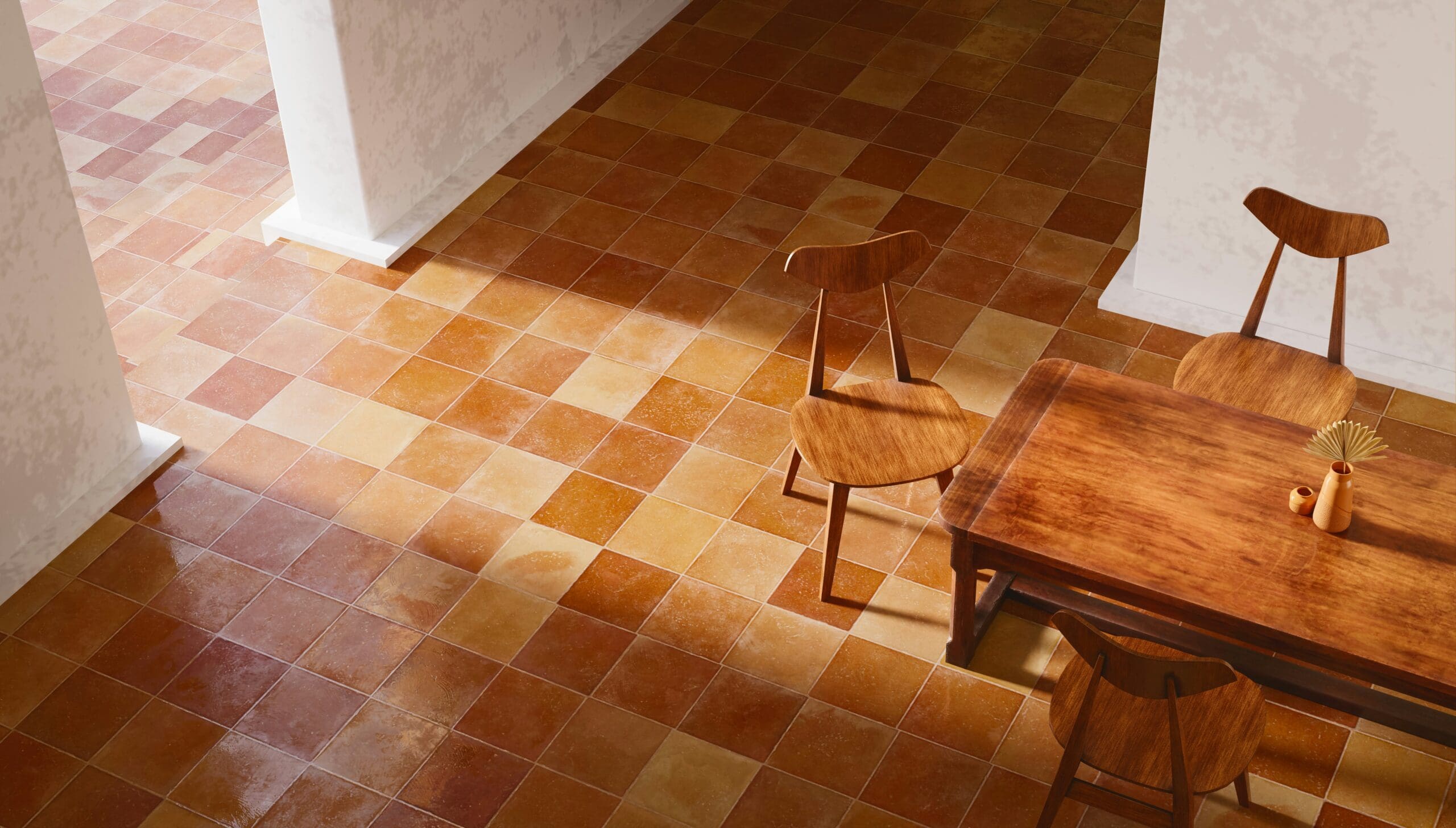 A cozy dining area featuring a wooden table and three matching chairs on a warm-toned, tiled floor. The tiles, interspersed with rustic carpets, vary in shades of brown and yellow, creating a homely atmosphere. Sunlight streams through an unseen window, casting soft shadows on the floor.