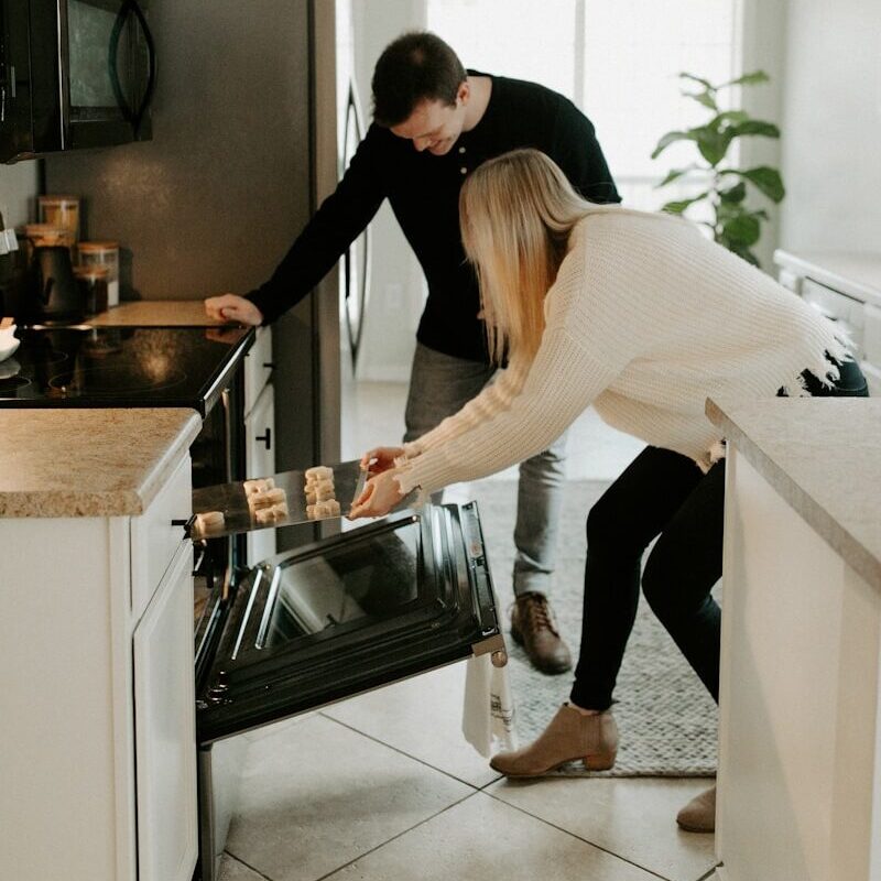 man and woman by open range oven