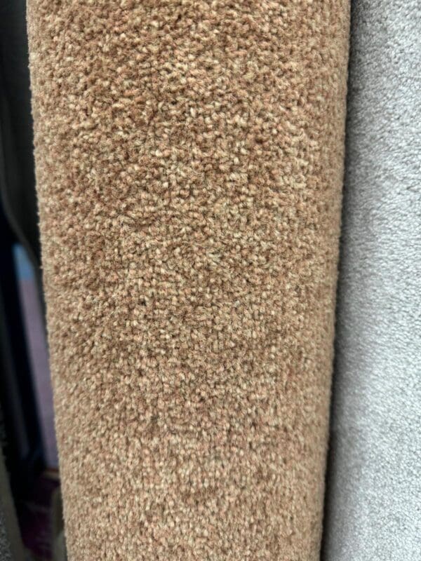 A close-up view of two rolls of carpet, with the Biscuit Prince 2x4m in a warm brown color on the left and another in a light gray color on the right. The texture of both carpets is clearly visible, showcasing their soft and dense pile.